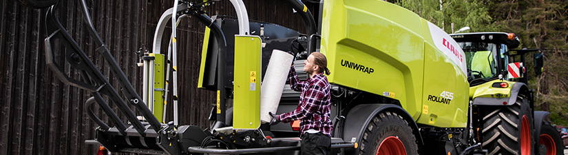 Ajankohtaiset kampanjat. Mies täyttää Claas Rollant -paalainta.