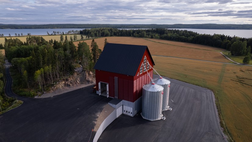 Mies istuu viljasiilon kivijalalla.