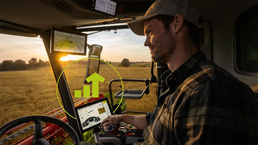 Mies istuu tyytyväisenä leikkuupuimurissa, jossa on Cemos-järjestelmä.