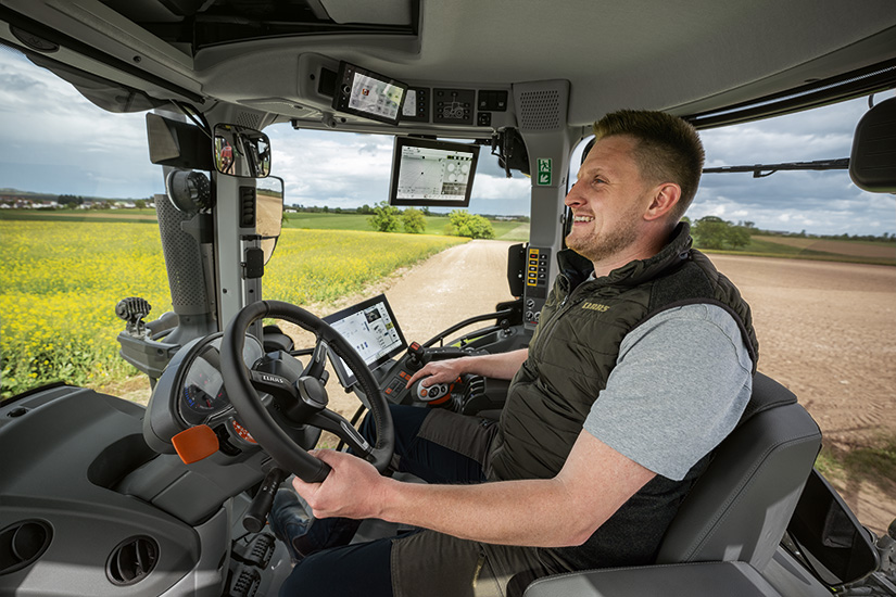 Mies istuu Claas Arion 5 -traktorin ohjaaomssa. On se ergonomista!