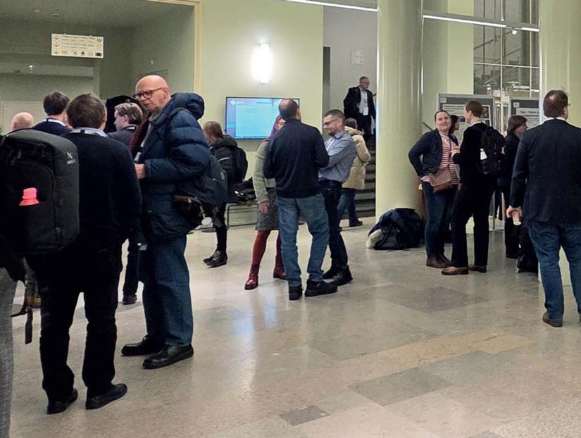 Konferenssivieraita keskustelemassa Helsingin yliopiston aulatilassa Maataloustieteen päivien yhteydessä.